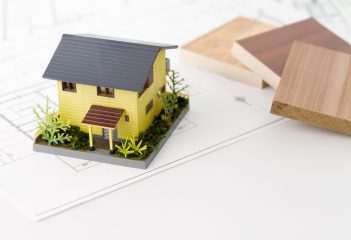 A model of a house that embodies green building and eco-friendly principles, with samples of lumber and floor plan diagrams.