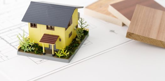 A model of a house that embodies green building and eco-friendly principles, with samples of lumber and floor plan diagrams.